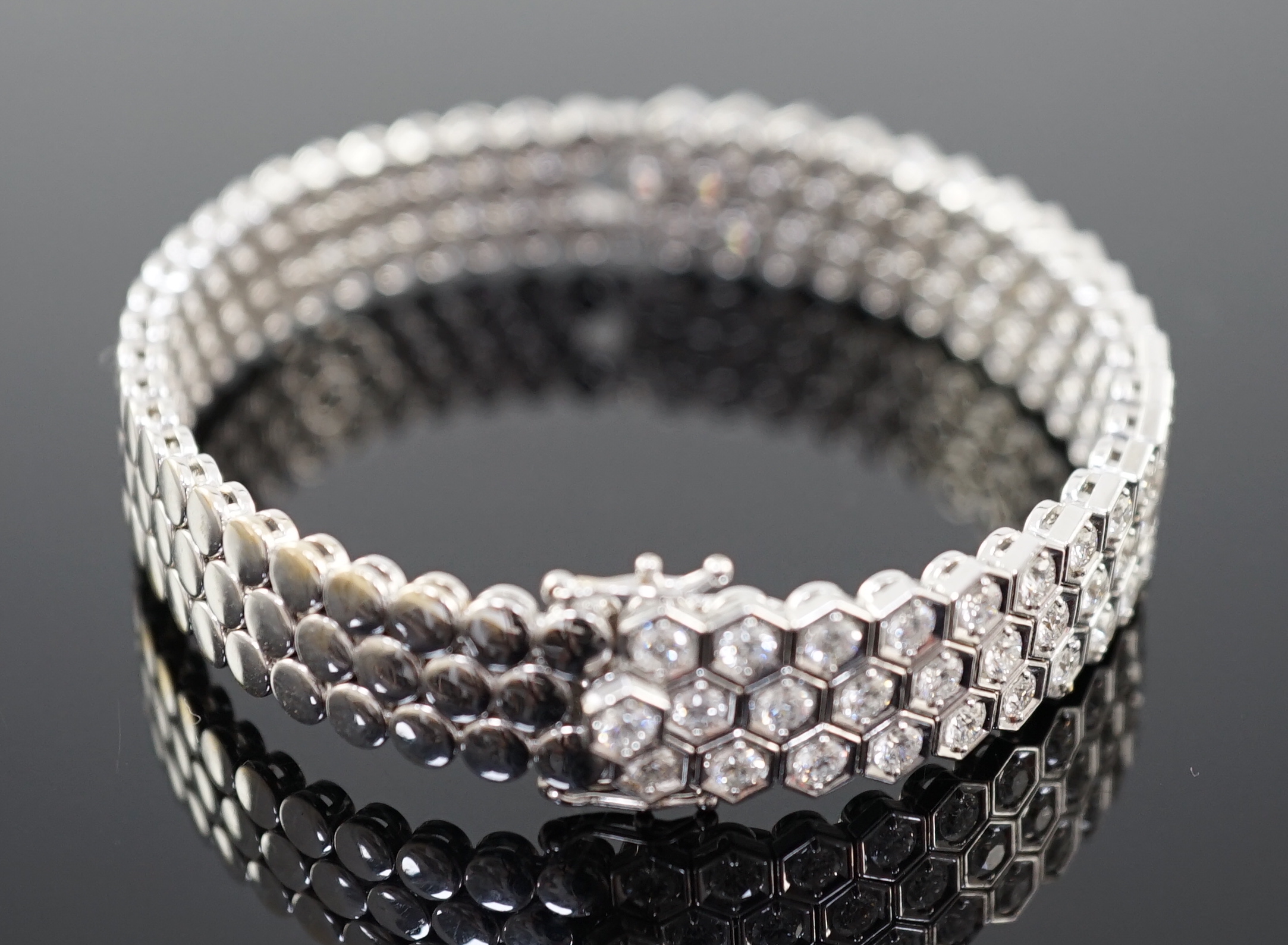 A modern 18ct white gold and diamond cluster set hinged bangle